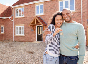 stock-photo-portrait-of-couple-holding-keys-standing-outside-new-home-on-moving-day-1470584330