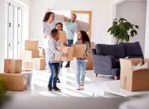 stock-photo-smiling-family-carrying-boxes-into-new-home-on-moving-day-1470578714